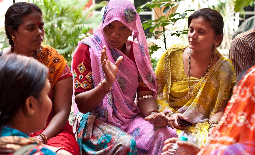 Group Of Indian Women Sitting And Talking Outdoors