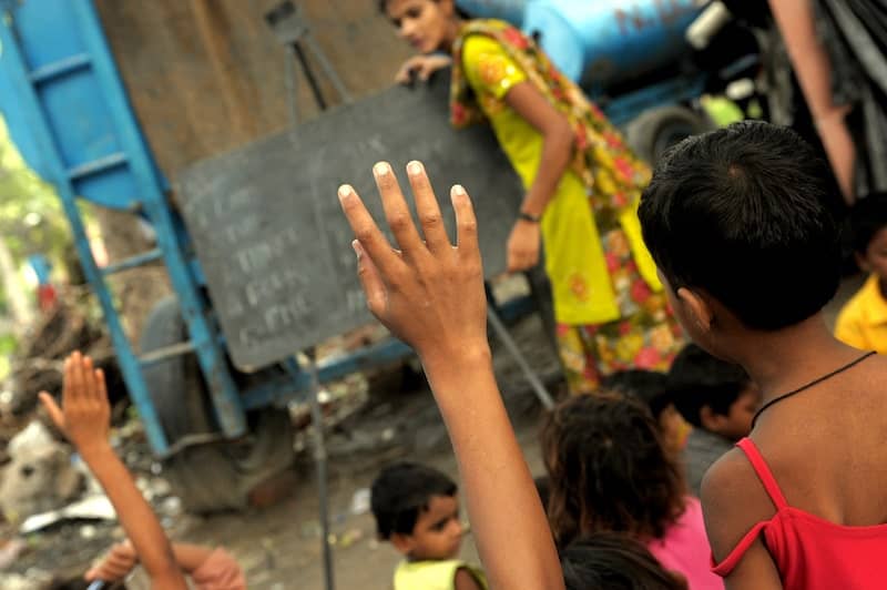 Close up photo of southeast Asian schoolchild's raised hands in class