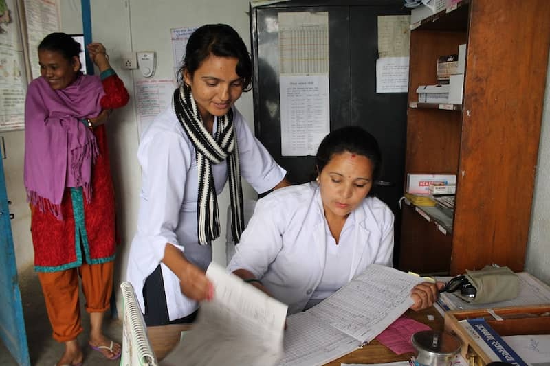 Photo Of Women Researchers Or Doctors In Office, Looking At Records