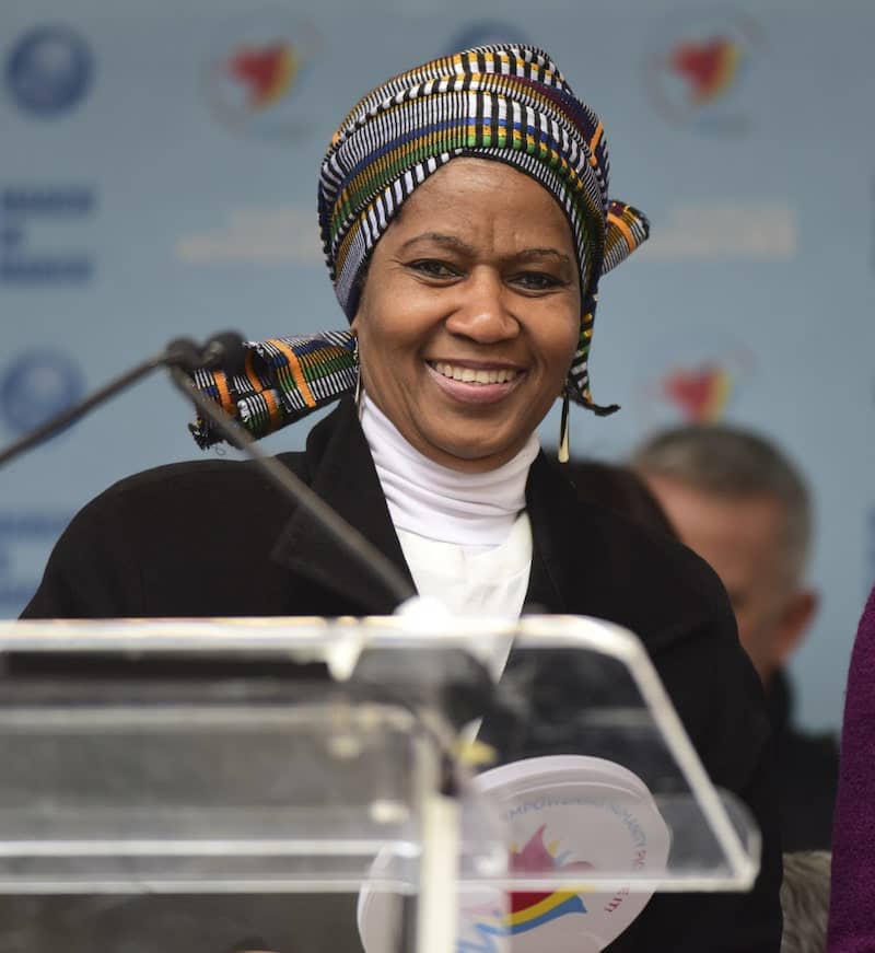 Photo of African woman at a speech podium smiling at the camera