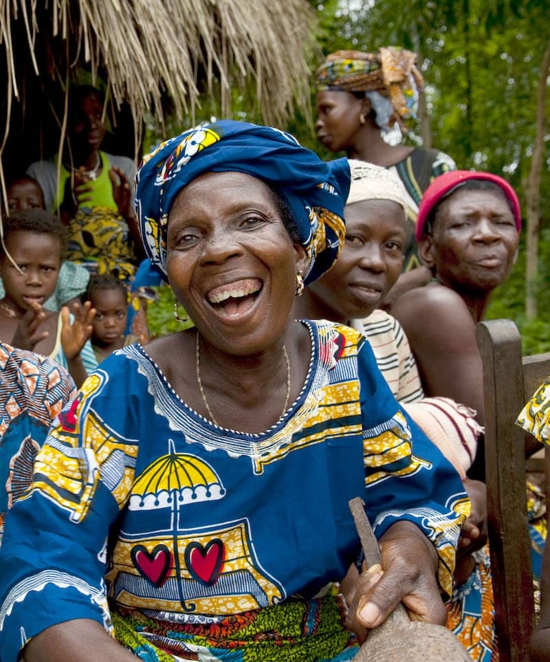 Photo of smiling African woman with women and children in the background