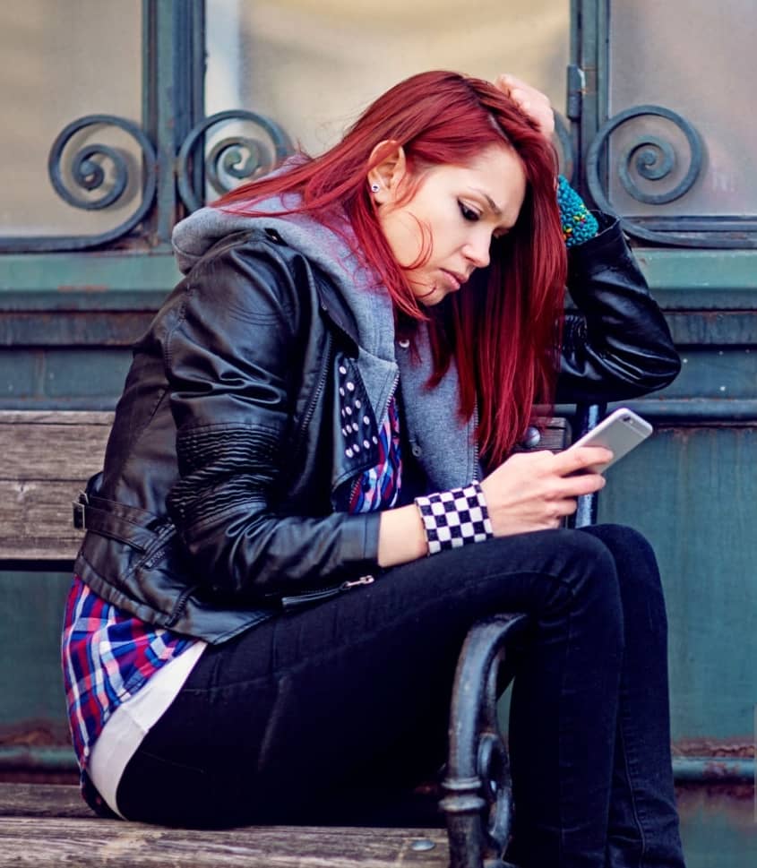 Young woman looking concerned at her mobile phone