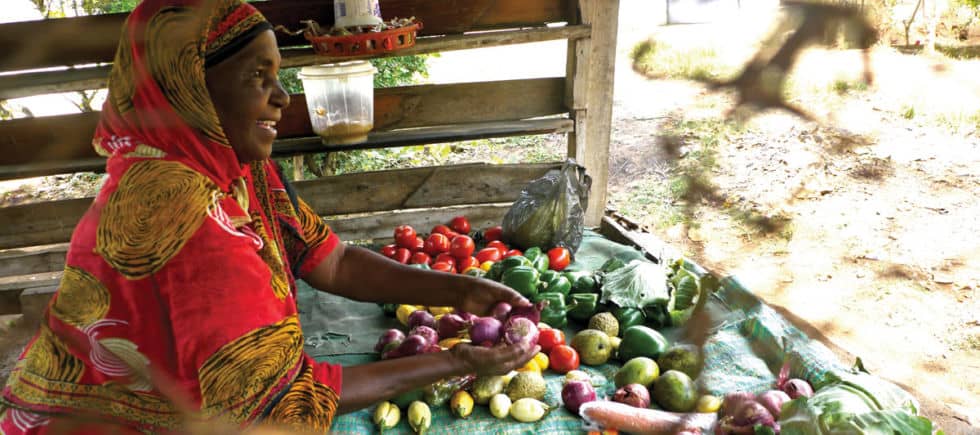 Black woman selling fresh vegetables at a market