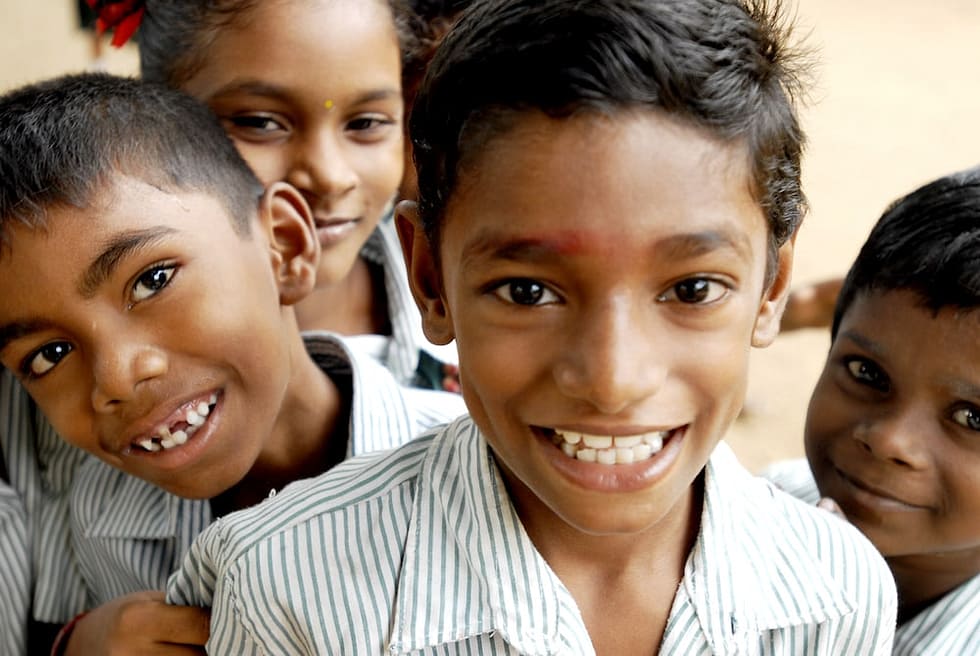 Photo of southeast Asian school children smiling at the camera